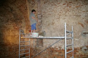 Práce v kazemate: Oprava ryhy po zvislej kanalizácii v stene bastióna.